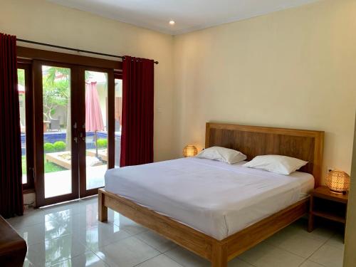 une chambre avec un lit et une grande fenêtre dans l'établissement The Sampan, à Canggu