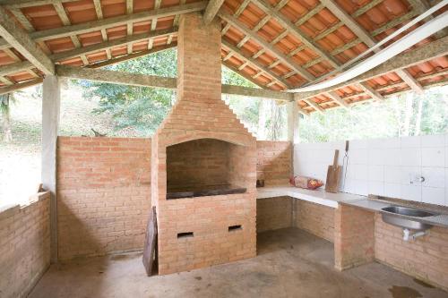 an outdoor kitchen with a brick oven and a sink at Tranquilidade e boa localização na Mata Atlântica in Paraty