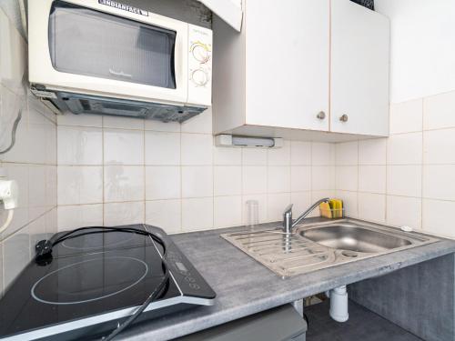 une cuisine avec un évier et un micro-ondes dans l'établissement Studio mezzanine pour 2 personnes avec terrasse en centre station à Biscarrosse - FR-1-521-204, à Biscarrosse