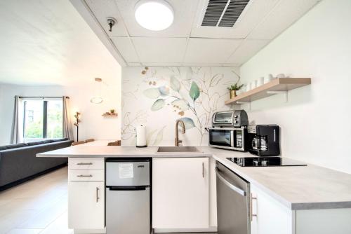 a kitchen with white cabinets and a sink at Lovely Studio near Universal in Orlando