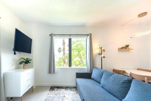 a living room with a blue couch and a window at Lovely Studio near Universal in Orlando