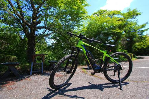a green bike parked on the side of a street at Gokase Campsite Camping and Guesthouse in Gokase