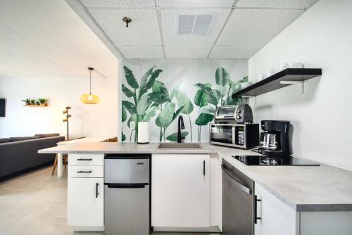 a kitchen with white cabinets and a plant mural on the wall at Studio near Universal Studios with great view in Orlando