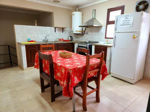 a kitchen with a table and a white refrigerator at Departamento Sarmiento in Rosario de la Frontera