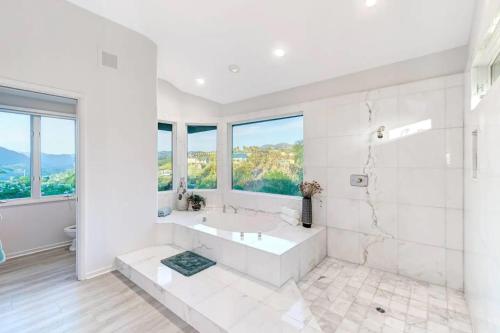a white bathroom with a tub and a sink at Luxury Modern Chateau near wineries & beaches in Fallbrook