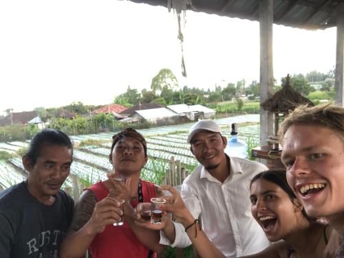 a group of people posing for a picture with wine glasses at Batur Homestay and Lodge in Bangli
