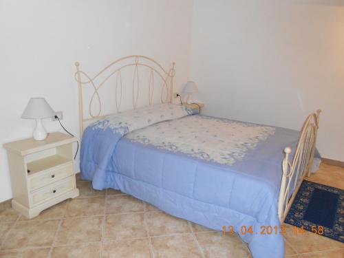 um quarto com uma cama e uma mesa de cabeceira em B&B Perdalonga em Ghilarza