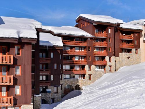un bâtiment dans la neige avec des toits recouverts de neige dans l'établissement Studio confortable au centre avec balcon, animaux admis - FR-1-181-2369, à La Plagne Tarentaise