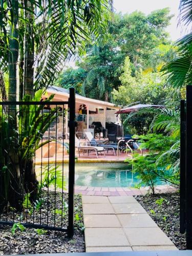a garden with a fence and a swimming pool at South Pacific Bed & Breakfast in Clifton Beach