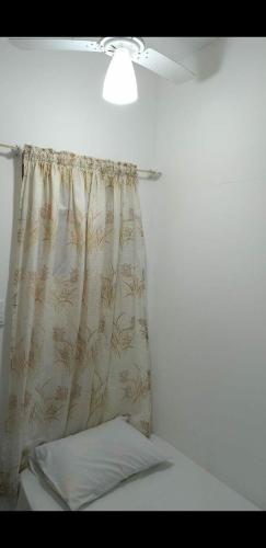 a bedroom with a curtain and a bed with a pillow at Pousada Landus in São Paulo