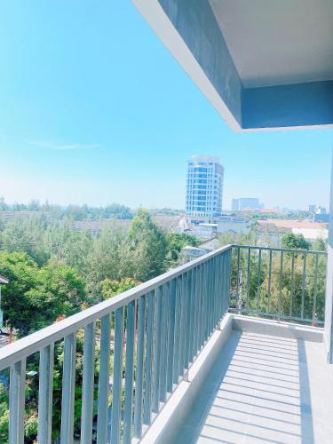 a balcony with a view of trees and a building at Light House Hostel in Da Nang
