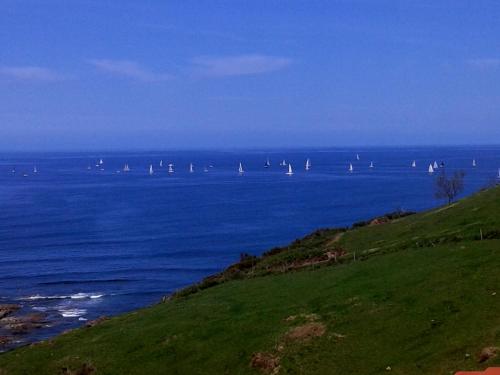 a large body of water with sail boats in it at Posada Punta Liñera in San Vicente de la Barquera