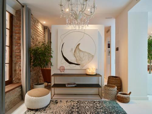 a living room with a chandelier and a table at LD Convento Cister in Málaga