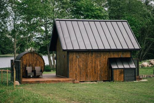 a large wooden building with a deck and a chair at Auksi puhkemaja-1 in Auksi
