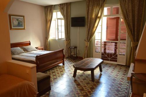 a bedroom with a bed and a table and windows at Dar Omar Khayam in Tangier