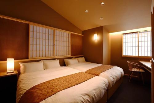 a bedroom with a large bed and a desk at Kyoyado Heianshiki in Kyoto