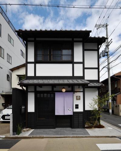 a black and white house with a purple door at Kyoyado Heianshiki in Kyoto