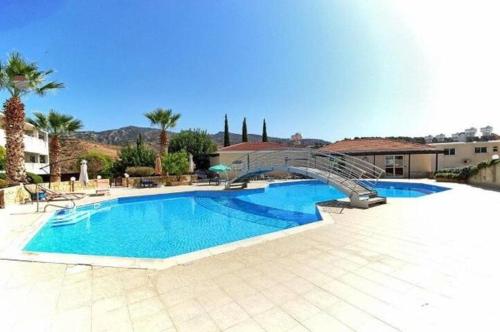 een groot zwembad met een trap naast een gebouw bij Peyia Resort Apartment in Peyia