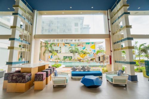 un vestíbulo con sofás y una piscina en Solea Palm Resort Mactan, en Mactan