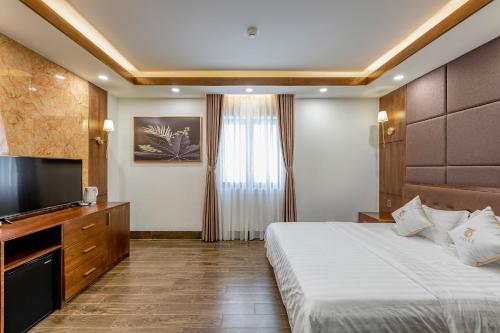 a hotel room with a bed and a flat screen tv at Hotel Trí Lê in Cao Lãnh
