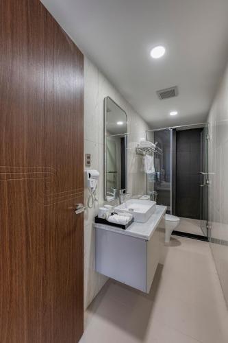 a bathroom with a sink and a toilet and a shower at Hotel Trí Lê in Cao Lãnh
