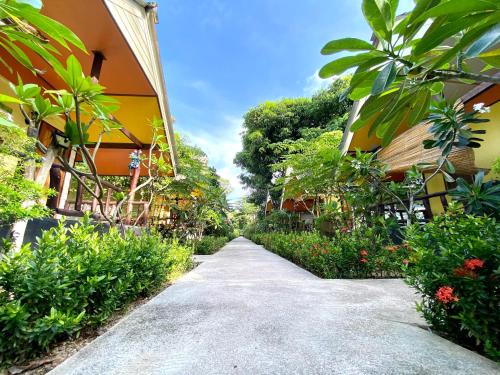 a garden path between two buildings with plants at Long Beach Garden Resort in Ko Lanta