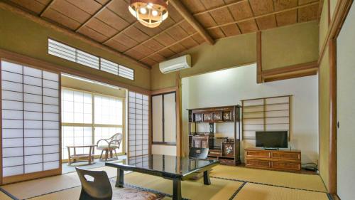 a living room with a table and a tv at Irorinoyado Ashina in Aizuwakamatsu