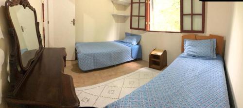 a bedroom with two beds and a mirror and a dresser at Tranquilidade e boa localização na Mata Atlântica in Paraty