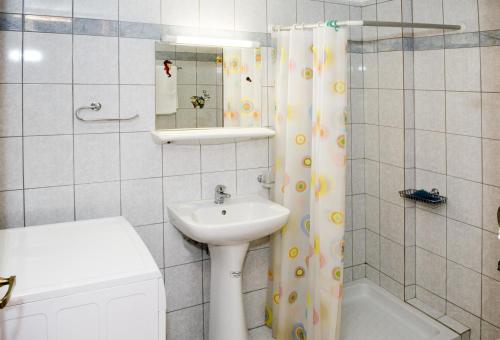 a bathroom with a sink and a shower curtain at Margarita Αpartments Sea View in Palaiochóra