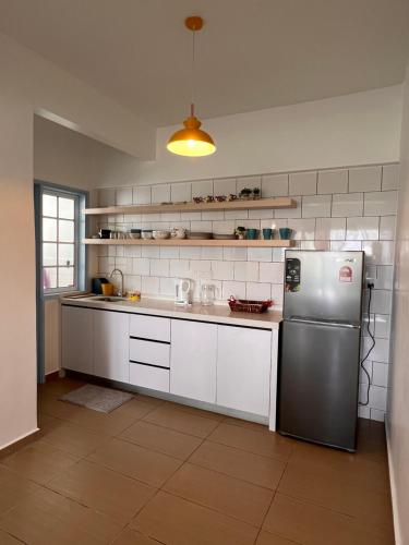 a kitchen with a stainless steel refrigerator and white cabinets at The Antler Silverpark Fraser's Hill in Bukit Fraser