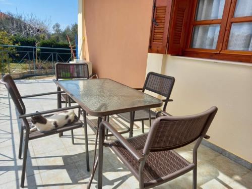 stół i krzesła na patio z psem śpiącym na nim w obiekcie Maria's House 1 w mieście Pirgos