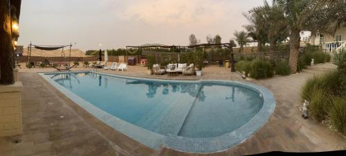 a large swimming pool in a yard with a patio at Farm Lebanon in Abu Dhabi
