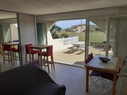 un salon avec un canapé, une table et des chaises dans l'établissement Les Maisons sur la plage, T2 les pieds dans l'eau, au Cap d'Agde