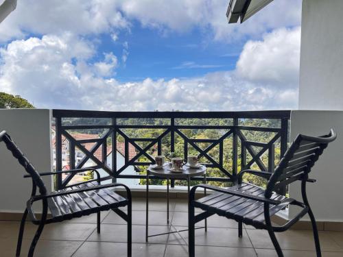 a balcony with two chairs and a table on a balcony at The Antler Silverpark Fraser's Hill in Bukit Fraser