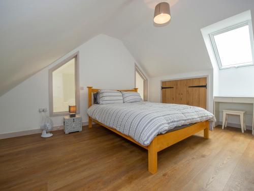 a bedroom with a bed in a white room at Owl Lodge in Wedmore