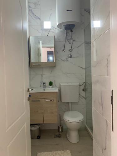 a bathroom with a toilet and a sink and a mirror at Rasi Luxury Apartments in Ulcinj
