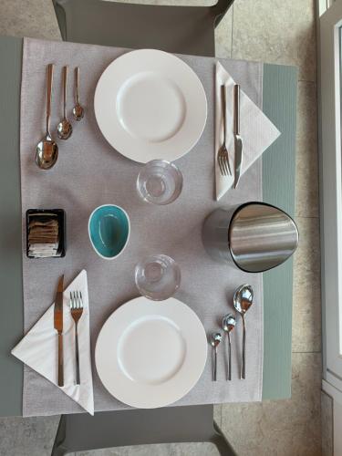 a table with white plates and silverware on it at Casale al Foino in Induno Olona