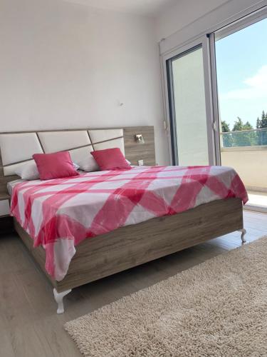 a bedroom with a bed with a red and white blanket at Rasi Luxury Apartments in Ulcinj
