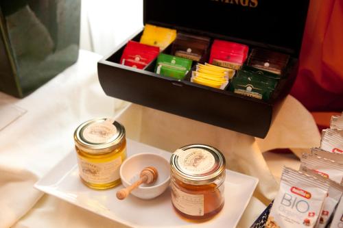 two jars of honey on a plate next to a box at Hotel Mini Palace - Country House in Molinella