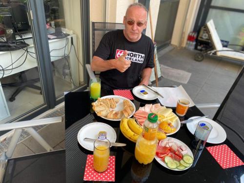 a man sitting at a table with plates of food at BREEZE DU NORD in Grand Baie