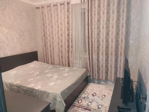 a small bedroom with a bed and a window at Светлая и уютная квартира в южной части Бишкека! in Bishkek