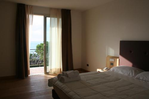 a bedroom with a bed and a view of the ocean at Villa Eva Hotel in Ventimiglia
