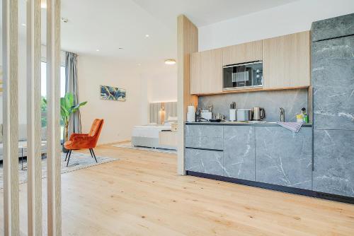 a kitchen with a counter and a chair in a room at BRIGHT: Rosenheim Aicherpark in Rosenheim