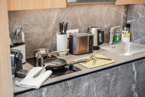 a kitchen counter with a stove and a sink at BRIGHT: Rosenheim Aicherpark in Rosenheim