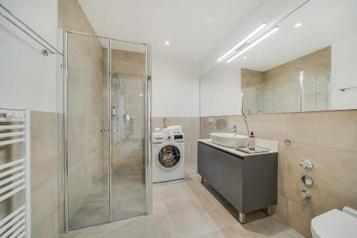 a bathroom with a sink and a washing machine at BRIGHT: Rosenheim Aicherpark in Rosenheim