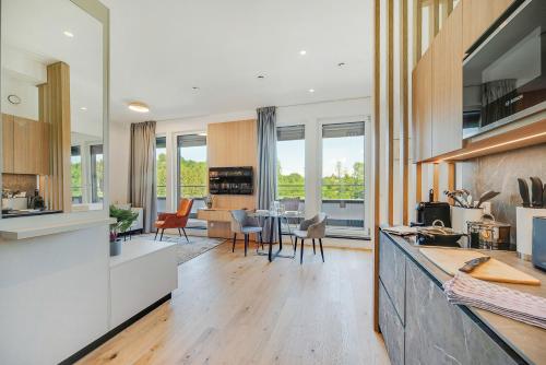 a kitchen and living room with a table and chairs at BRIGHT: Rosenheim Aicherpark in Rosenheim