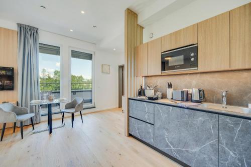 a kitchen with a counter and a table with chairs at BRIGHT: Rosenheim Aicherpark in Rosenheim