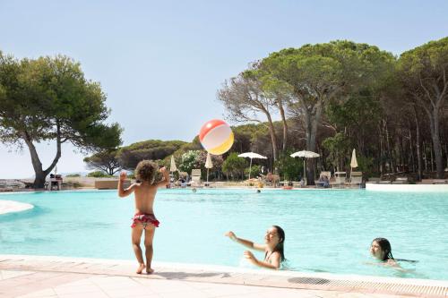 a young boy playing with a frisbee in a swimming pool at Club Hotel Marina Seada Beach in Budoni