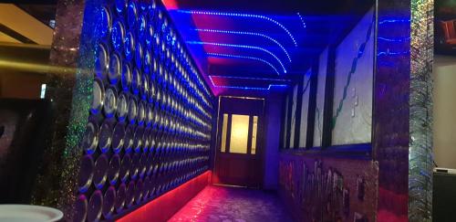 a hallway with purple and blue lights on a wall at HOTEL THE TAKSONZ - Opposite Railway Station in Ludhiana
