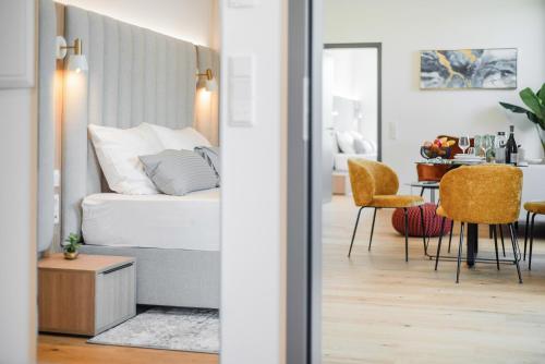 a bedroom with a bed and a table and chairs at BRIGHT: Rosenheim Aicherpark in Rosenheim